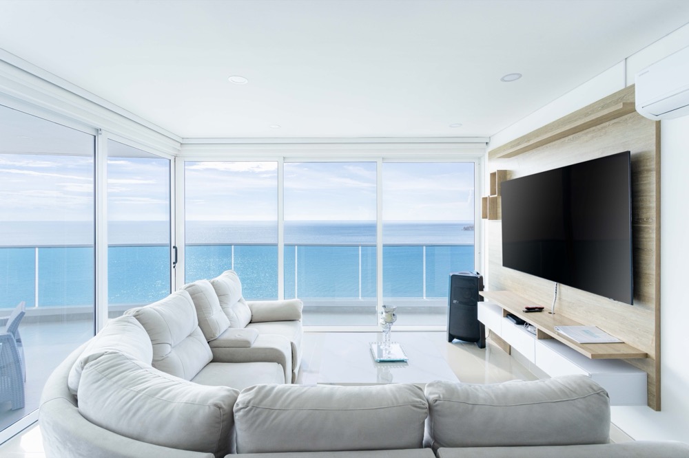 A bright living room with wide windows facing the ocean